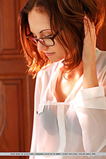 Sade mare wearing black-rimmed glasses, sheer white chiffon shirt, black pencil skirt, and matching black strappy sandals, sade mare portrays a lusty secretary