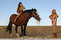 Two busty maidens frolicking in the barren outskirts of a town.